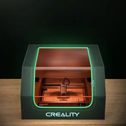 A Creality Falcon 3D printer from the Air Purifier Bundle, featuring a transparent top and green accent lights, is on display. It offers quiet functionality with low-noise operation, all while showcasing its interior printing mechanism.